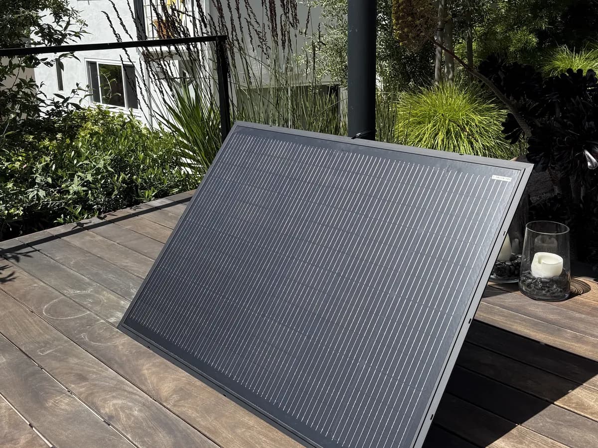 A Bright Saver solar panel angled toward the sun on a wooden deck